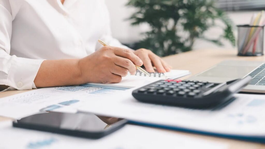 Documents comptables d'une association posés sur un bureau avec une calculatrice